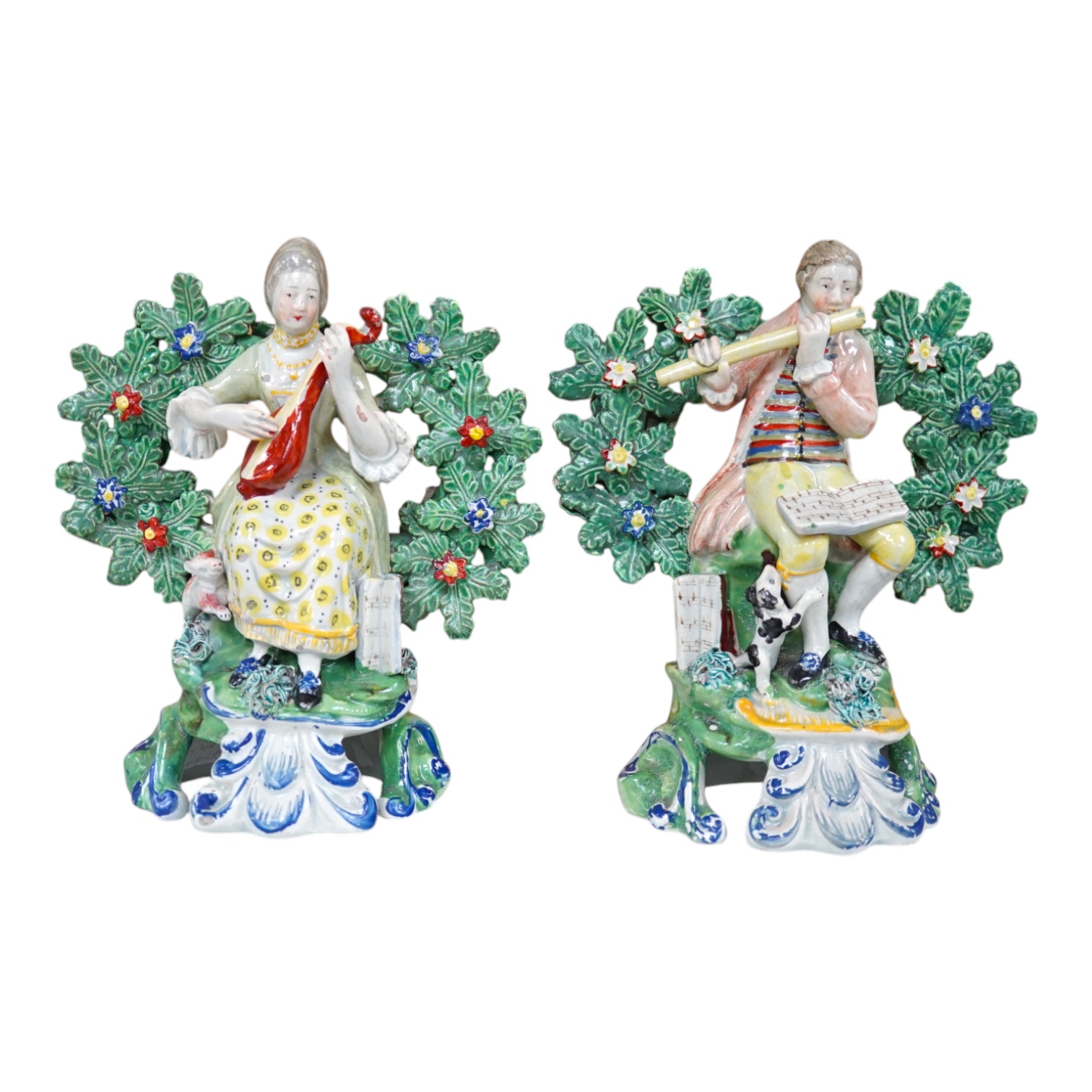 A pair of early 19th century pearlware groups of seated musicians with dogs, 15.5 cm high, Condition - minor faults otherwise fairly good, provenance - sold by Jonathan Horne Antiques